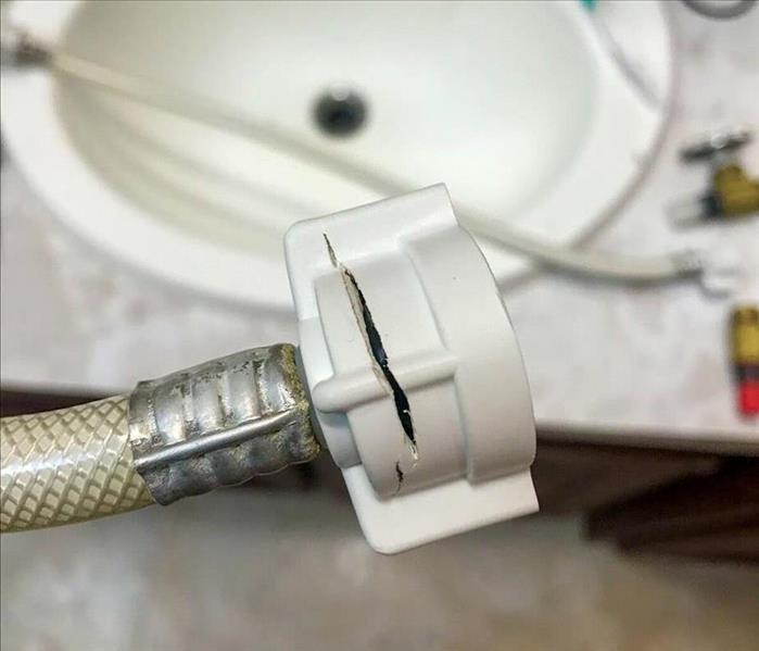 Broken pipe under a bathroom sink leads to water damage