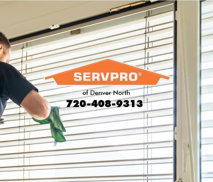 A technician is cleaning window blinds. 