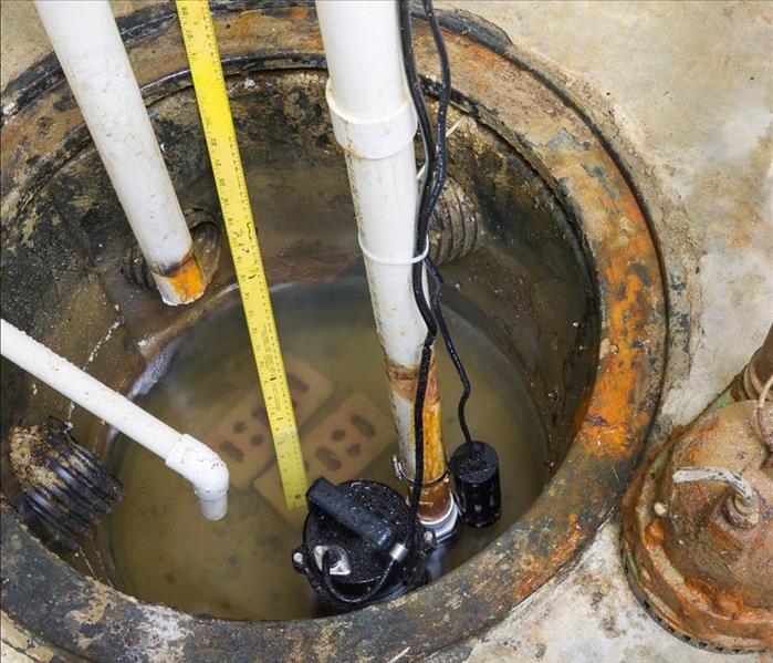 Installation of a new sump pump and the removal of the old obsolete rusty one with a high angle view of the pumps and more