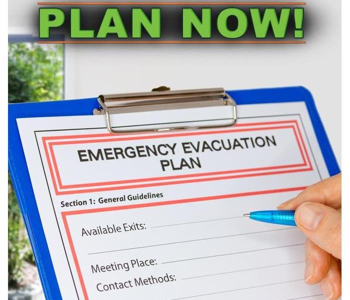 Hand writing an Emergency Evacuation Plan on clipboard beside Exit Door